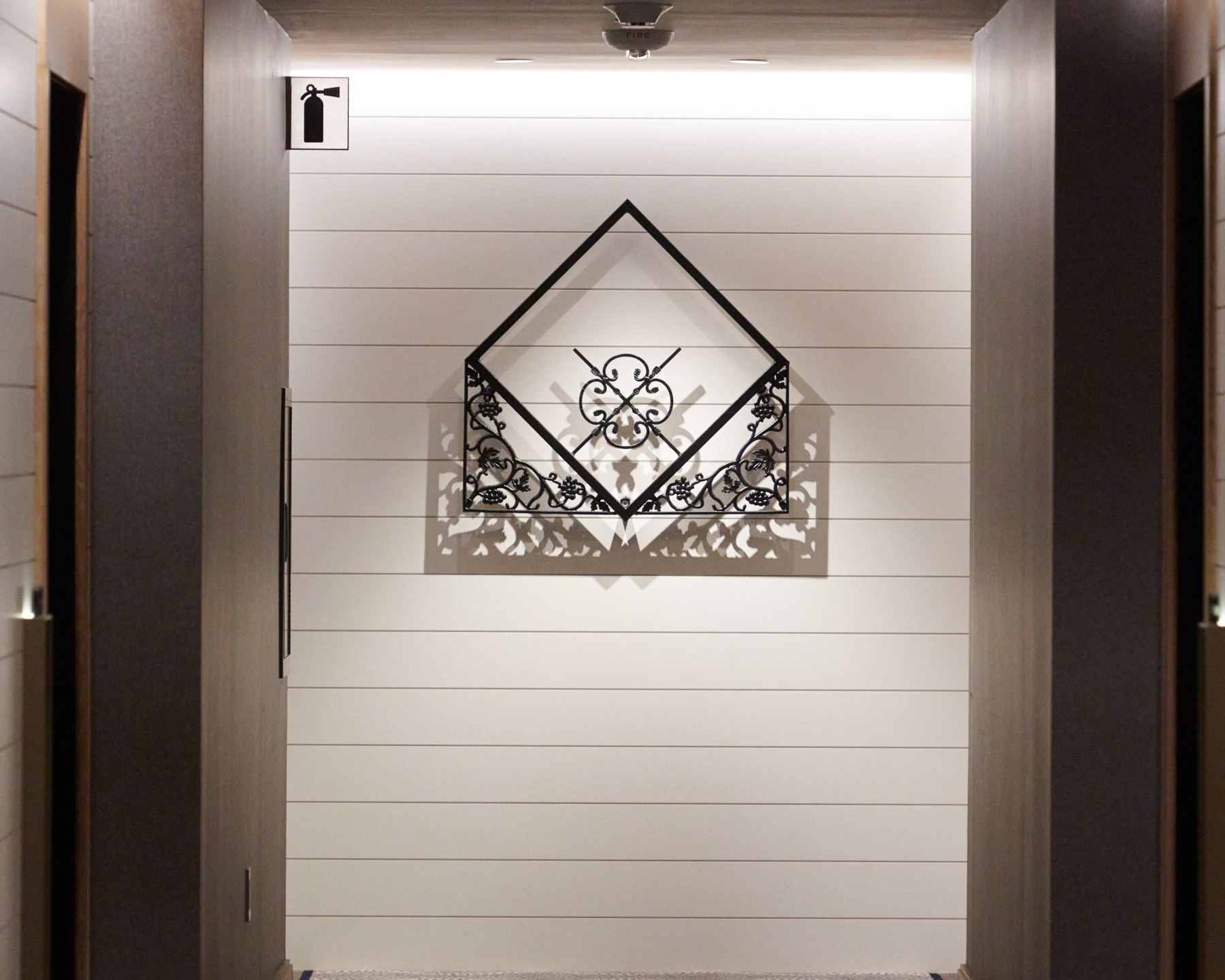 An angular ironwork sculpture installed at the end of a hotel corridor
