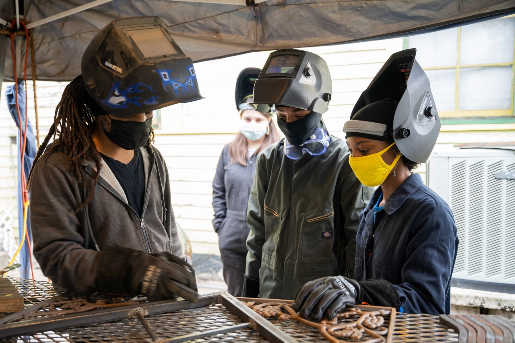 Jermaine Lindsey with collaborators working on iron sculptures in the studio