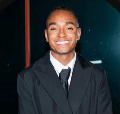 Jermaine Lindsey smiling in a black coat and tie